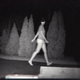 A blurry image of a young woman walking in the dark